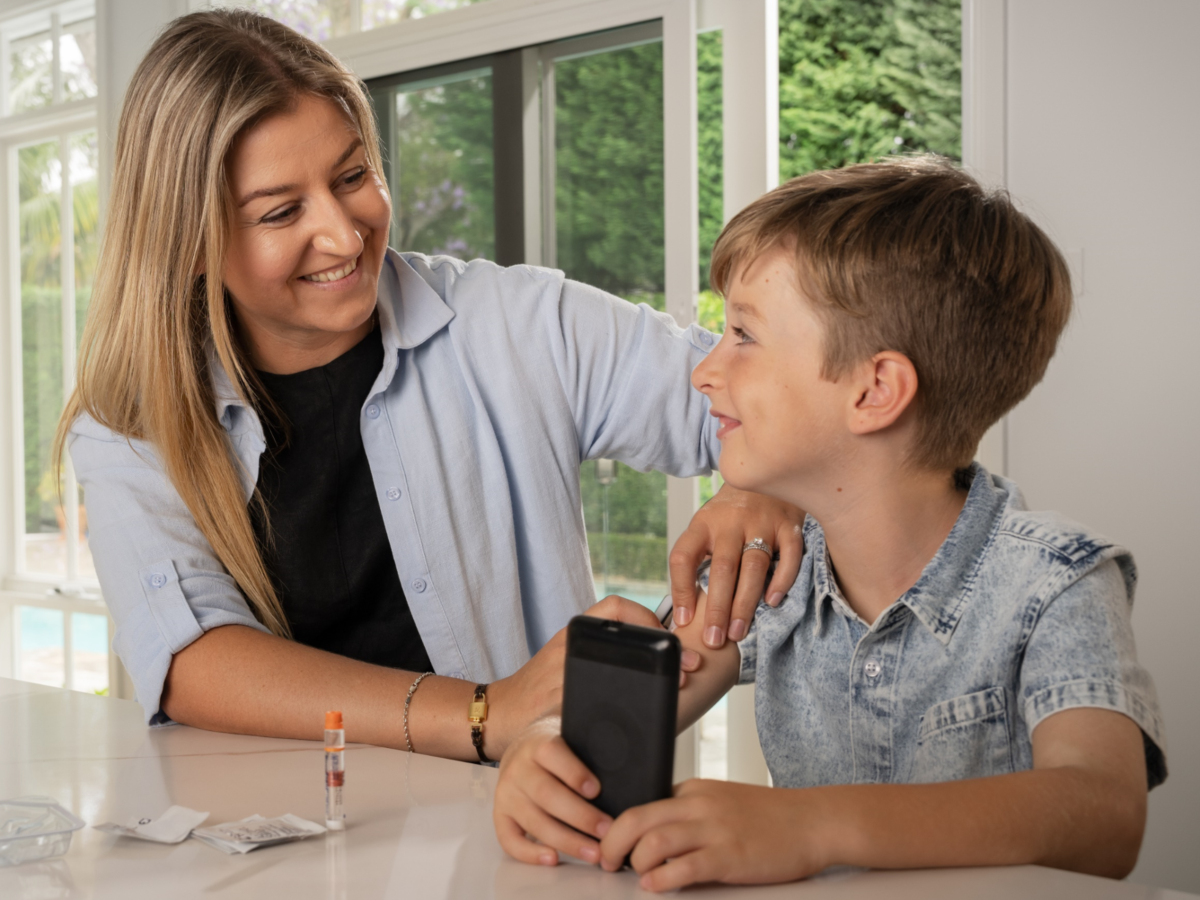 Omnipod Podder Tadhg with his mom sitting at a table