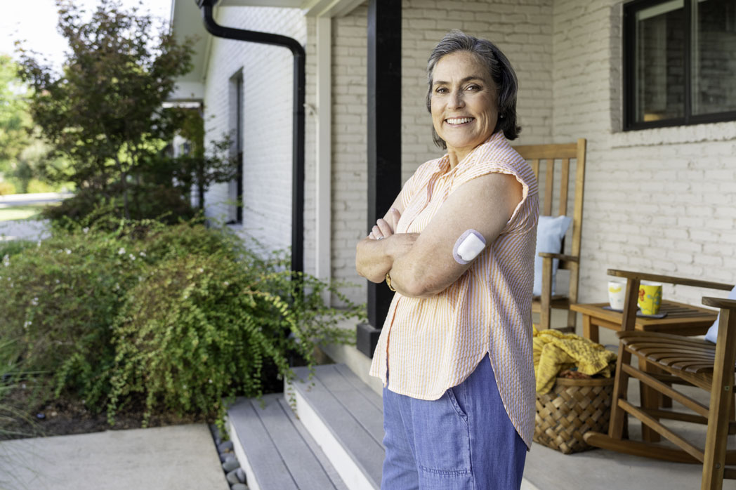 Podder Mary standing in front of a home with pod on her arm